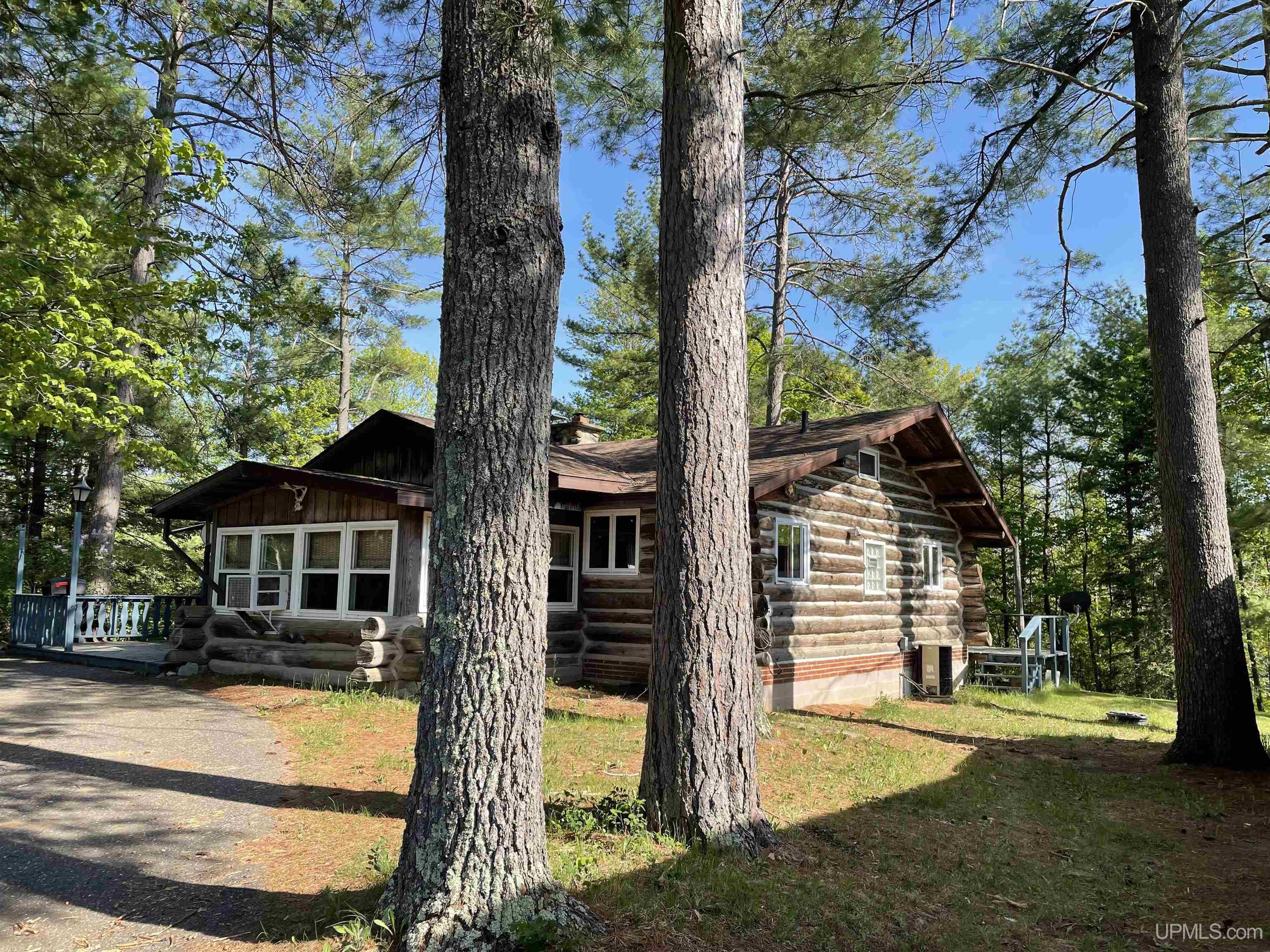 Well-crafted log home in the towering pines of the Northwoods! Year-round log home features 2 bedrooms on the main floor and a loft sleeping area with floor area being 10x12(not included in sq.ft). Floor to ceiling stone wood-burning fireplace is the focal point of the home. Custom kitchen cabinetry completes the rustic design. Enjoy your morning coffee on the back or front deck or the enclosed front porch, or screen gazebo, while watching the birds, deer, squirrels, etc. Wait, there is more... How about the 2br cottage? With some love, it will provide room for guests or rent for some extra income. 2 car detached garage with a loft area for storage tops this off.  Located near 2 golf courses and the Menominee River for excellent fishing and boating.