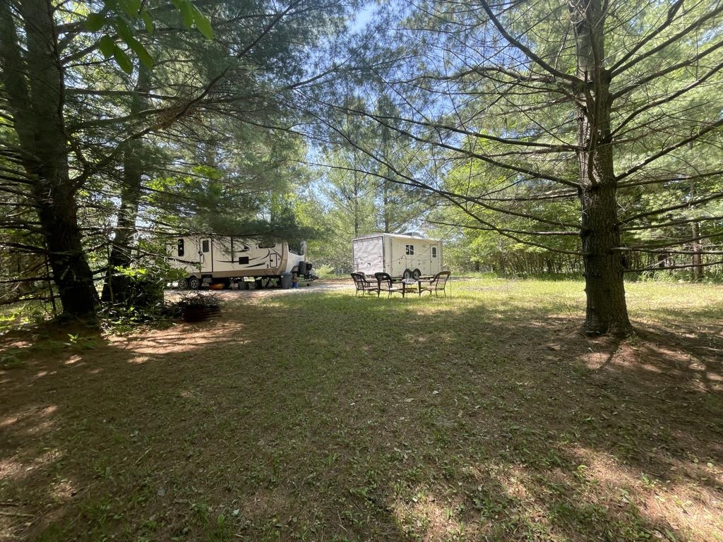 Over 3/4 acre to enjoy.   Shady lot with stream at back to enjoy in the spring.   Lot set up for 2 campers includes electric, gravel circle drive for easy set up and sewer hook-ups.  Also includes a fire pit and plenty of firewood. Ownership includes access to all of Sugar Springs amenities, 9 hole and 18 hole golf course, heated indoor pool, golf simulator, tennis and pickle ball, 2 all sport lakes, Lake Lancer and Lake Lancelot, beach club and more.   Enjoy year around activities and events.