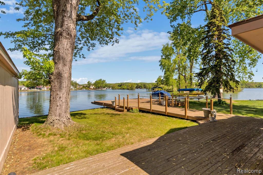 Dreaming of lake life this summer? This lovely home on all sports Pontiac Lake is exactly what you've been hoping for! Gorgeous 4 seasons sunroom overlooking the lake, complete with skylights, knotty pine walls and ceiling, upgraded quadruple pane windows and panoramic views. Large full bathroom just off the lake, perfect for showering off after a long day at the beach! Features a jetted tub + stall shower, vaulted ceilings and more skylights! Large kitchen was remodeled in 1989 and includes real wood cabinets, eat in kitchen island, dedicated pantry and all appliances included in the sale. Nice size family room and dedicated laundry room closet. Home also features 3 bedrooms plus an additional full bathroom down the hall. Real wood floors under all carpet in family room and bedrooms. Central AC. Finished attic space for additional storage. On the exterior enjoy a massive deck leading you to the water's edge/dock space, steel seawall, oversized 2 car detached garage, additional 1 car garage for storage just off the water, low maintenance landscape, long driveway with plenty of parking, newer concrete, and whole home generator! Not to mention the sunrise view every morning and sunsets every night! Move right in and start enjoying Michigan's lake life today!